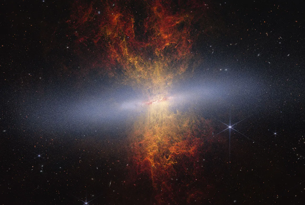 Composite image of edge-on spiral starburst galaxy Messier 82 as observed by NASA's James Webb and Hubble space telescopes. Hourglass-shaped plumes of gas are shooting outward from above and belo